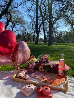 a picnic table with food and balloons on it