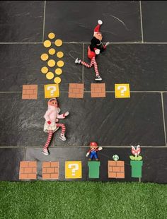 an overhead view of two people in costumes playing on a fake lawn with other figures