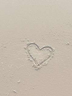 a heart drawn in the sand on a beach