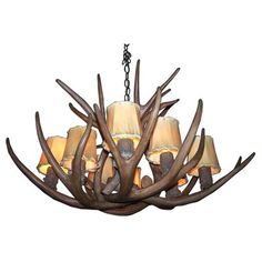 a chandelier made out of antlers with lamps hanging from the middle one