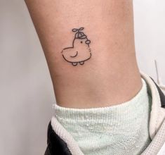 a small tattoo on the ankle of a woman's leg, with an animal