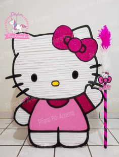 a hello kitty cardboard cutout with a pink bow holding a purple and white stick