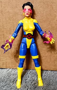 the action figure is wearing blue and yellow clothes with red eyeliners on her face