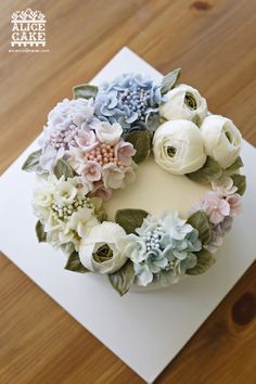 a cake decorated with flowers on top of a wooden table