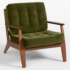 a green chair sitting on top of a white floor next to a wooden armrest