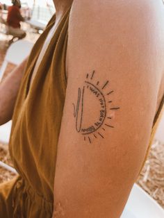 a person with a sun tattoo on their arm sitting in front of a white chair