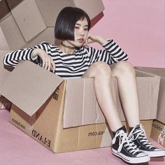 a woman sitting in a box with her legs crossed