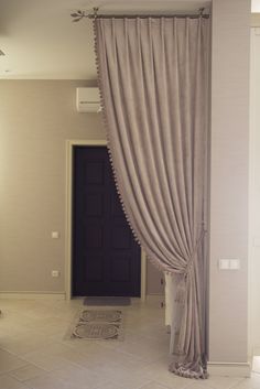 a living room with a door and some curtains