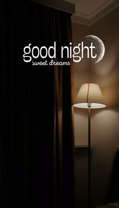 a lamp is next to a window with the words good night written on it in white