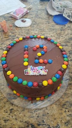 a birthday cake with chocolate frosting and colorful candies