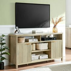 a flat screen tv mounted to the side of a wooden entertainment center in a living room