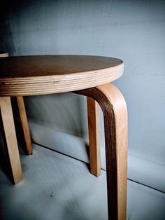 a wooden table sitting in front of a wall with no one on it's legs