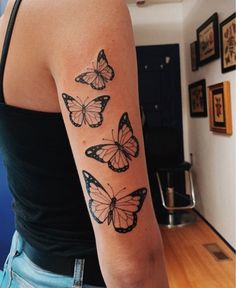 a woman's arm with three butterflies tattooed on the back of her left arm