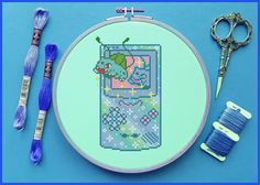 a cross - stitch pattern with scissors and thread next to it on a blue background