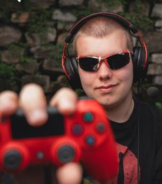 a young man wearing headphones and holding up a video game controller