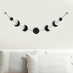 a white bed sitting next to a wall with a string of moon and stars on it