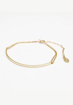 A delicate 14K/20 gold-filled flat cable chain bracelet with a gold plated curved bar measuring 2x1x50mm. The bracelet has a spring ring clasp with a 2 1/4" chain extension for size adjustability. The length of the bracelet is approximately 5.5", not including the chain extension. Details: 14k/20 gold filled flat cable chain bracelet gold plated curved bar (2x1x50mm) spring ring clasp 5.5" bracelet chain length + 2.25" chain extension for size adjustability Designed and assembled in the U.S.A. f Chic Adjustable Gold-plated Chain Bracelet, Adjustable 14k Gold-filled Bracelet With Gold Chain, Dainty Gold-plated Chain Bracelet With Lobster Clasp, Rose Gold 14k Gold-filled Bracelets With Adjustable Chain, Adjustable Hypoallergenic 14k Gold-filled Chain Bracelet, Los Angeles Design, Hand Screen Printed, Gold Bracelet Chain, Individual Style