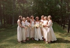 a group of women standing next to each other on top of a lush green field