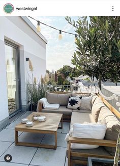 an outdoor living area with couches, tables and plants on the roof top deck