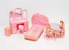 a doll house with furniture and accessories including a bed, dressing table, dresser and mirror