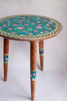 a small wooden table with floral designs on it