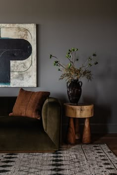 a living room with a couch, table and painting on the wall