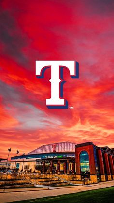 the texas rangers stadium at sunset with red and blue clouds in the sky over it