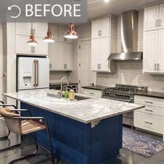 a kitchen with white cabinets and blue island