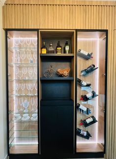 a wine cabinet with several bottles and glasses in it