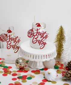 there are two jars that say santa baby on the table next to some christmas decorations