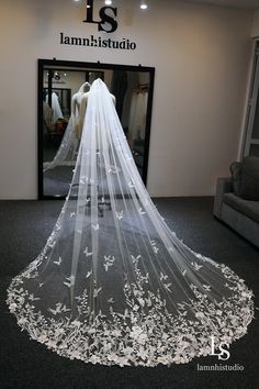 a wedding veil is displayed in front of a mannequin's headdress