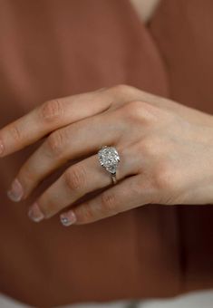 a woman's hand with a diamond ring on it