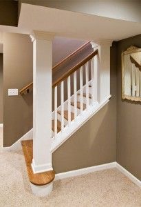 an empty living room with stairs leading up to the second floor and a mirror on the wall