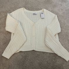 This Is A Knit Sweater From Hollister In An Off-White Color. It Is Brand-New And Has The Tags Attached. It Is A Bit Of An Oversized Fit And The Buttons Are Functioning. White Cable Knit Button-up Outerwear, Cozy White Button-up Cardigan, White Button-up Cable Knit Cardigan, White Knit Sweater With Buttons, White Knit Sweater With Button Closure, White Cable Knit Button-up Cardigan, White Cable Knit Button-up Sweater, White Knit Button-up Sweater, White Cozy Cardigan With Button Closure