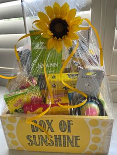 a sunflower sitting on top of a yellow box filled with lots of goodies