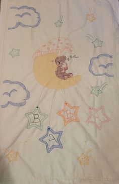 a baby's crib with stars and a teddy bear in the sky on it