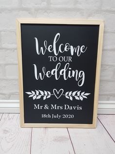 a black and white wedding sign with the words welcome to our wedding written on it