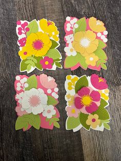 four flower stickers sitting on top of a wooden table