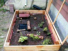 an open wooden box filled with dirt and plants