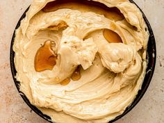 an overhead view of a cake in a pan with peanut butter on top and icing