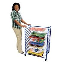 a woman standing next to a metal rack with books and magazines on top of it