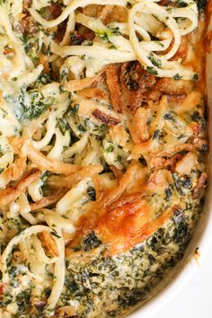 a casserole dish with spinach, cheese and chicken in it on a white plate