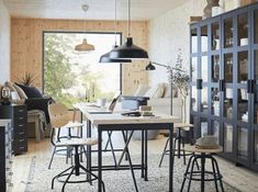 a dining room table and chairs in front of a bookcase