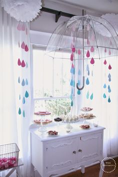 a baby shower is displayed in the window with an umbrella hanging from it's rod