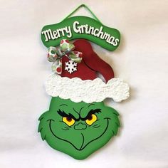 a christmas ornament hanging on the wall with an angry grin face and hat