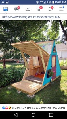 a small house made out of wood in the grass