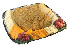 a platter with crackers, cheese and grapes