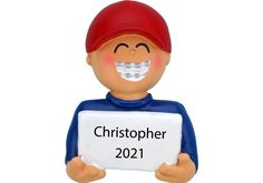 a ceramic figurine holding a sign that says,'christopher 2012 '