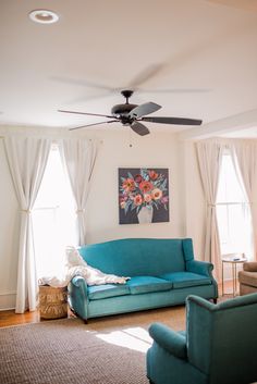 a living room with two couches and a ceiling fan in the middle of it