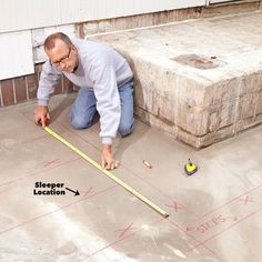 a man is measuring the floor with a tape measure and some other items around him